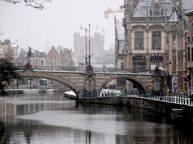 Pont Saint-Michel et la Lys sous la neige à Gand, château des Comtes au fond, une escapade d'hiver en Belgique en janvier