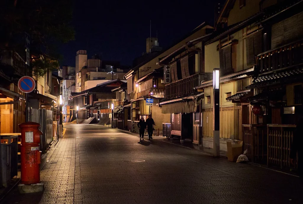 Rue Hanamikoji dans le quartier de Gion à Kyoto à la nuit tombée, bordée de maisons de thé en bois traditionnelles