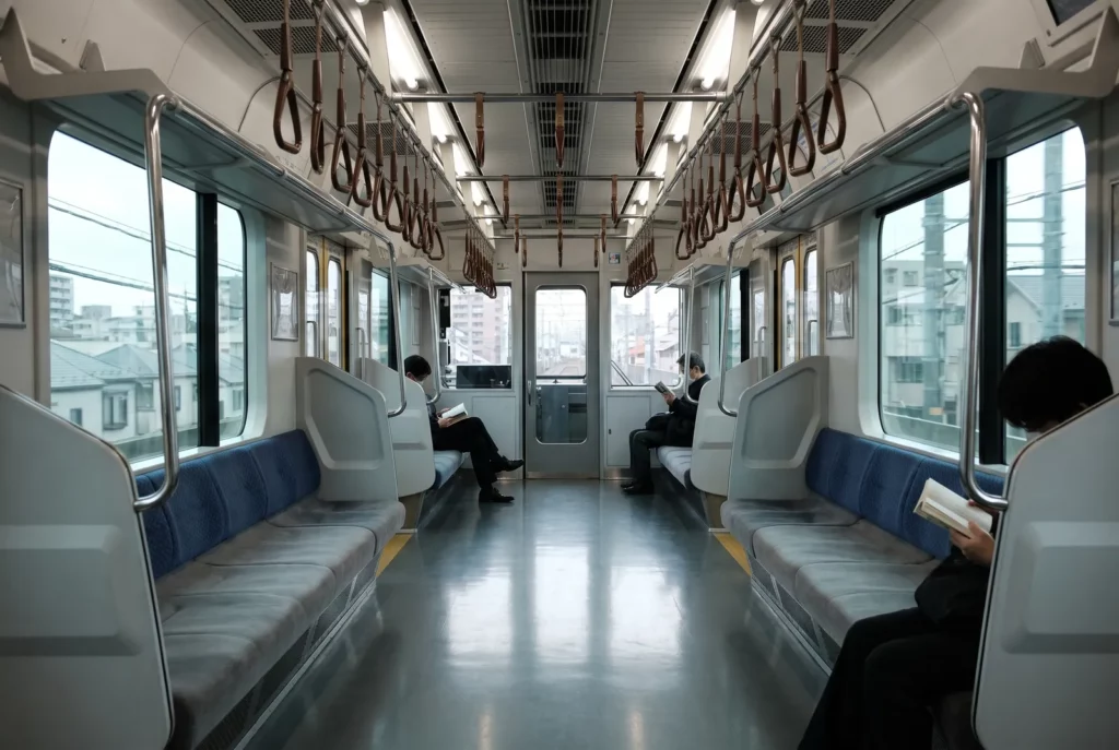 Passagers silencieux dans une rame de train de banlieue à Tokyo, symbole de la discrétion dans les transports au Japon