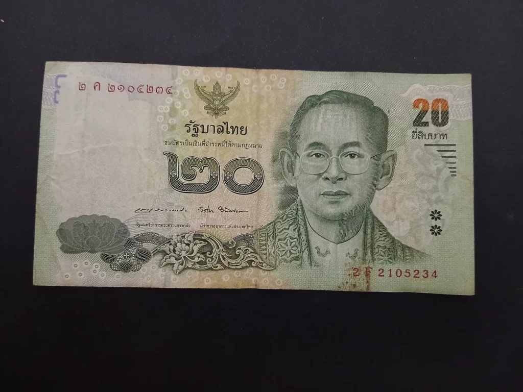 Billet de 20 bahts à l'effigie du roi Rama IX, une monnaie à manier avec respect lors des pourboires en Thaïlande