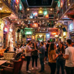 Foule dans un ruin bar de Budapest avec murs en briques, guirlandes lumineuses et décor éclectique la nuit.