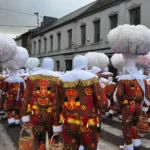 Gilles de Binche vus de dos en costume brodé de lions et chapeau de plumes d’autruche, emblème du folklore belge au carnaval