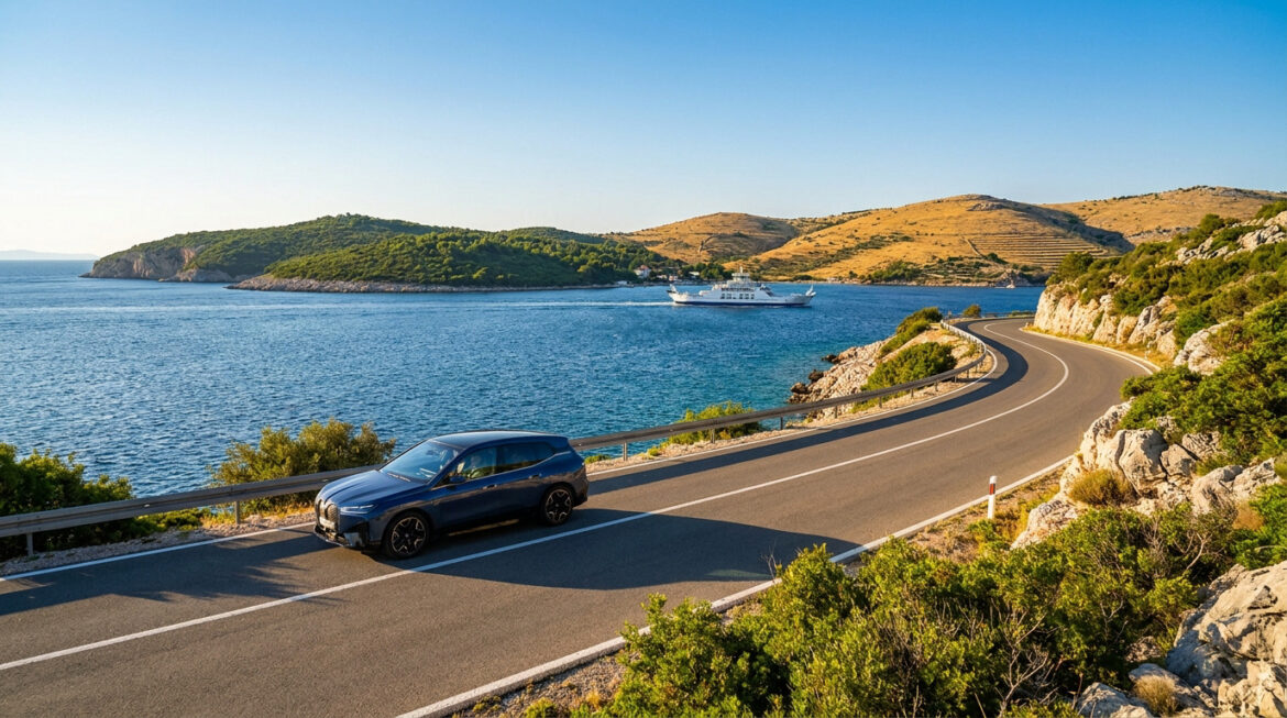 Une voiture bleue circulant sur une route côtière sinueuse avec un ferry naviguant en mer en arrière-plan.