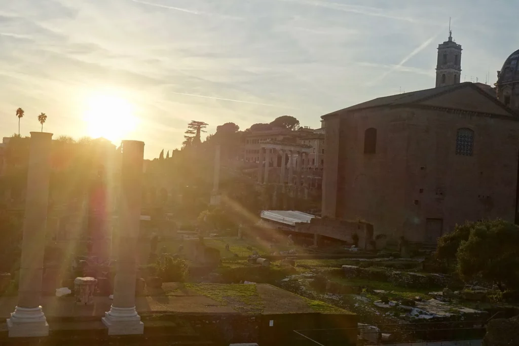Ruines du Forum romain baignées de lumière dorée au coucher du soleil, à Rome, destination soleil et culture en avril