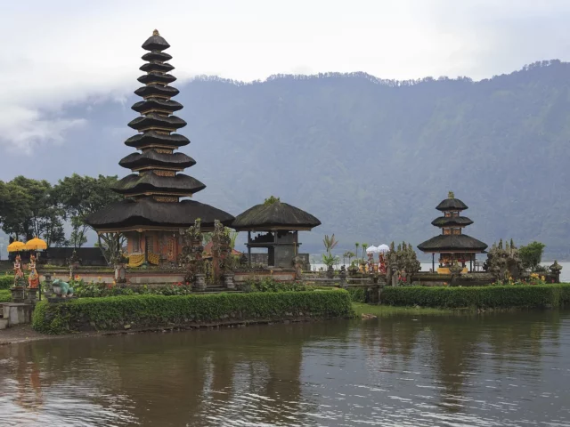 Temple Pura Ulun Danu Bratan au bord du lac Bratan à Bali, ses pagodes meru se reflétant dans l'eau au matin
