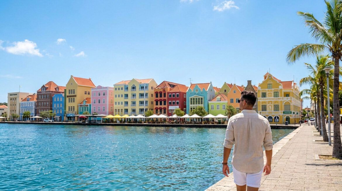 Un homme regarde les célèbres façades coloniales colorées de Willemstad, à Curaçao, au bord de l'eau.