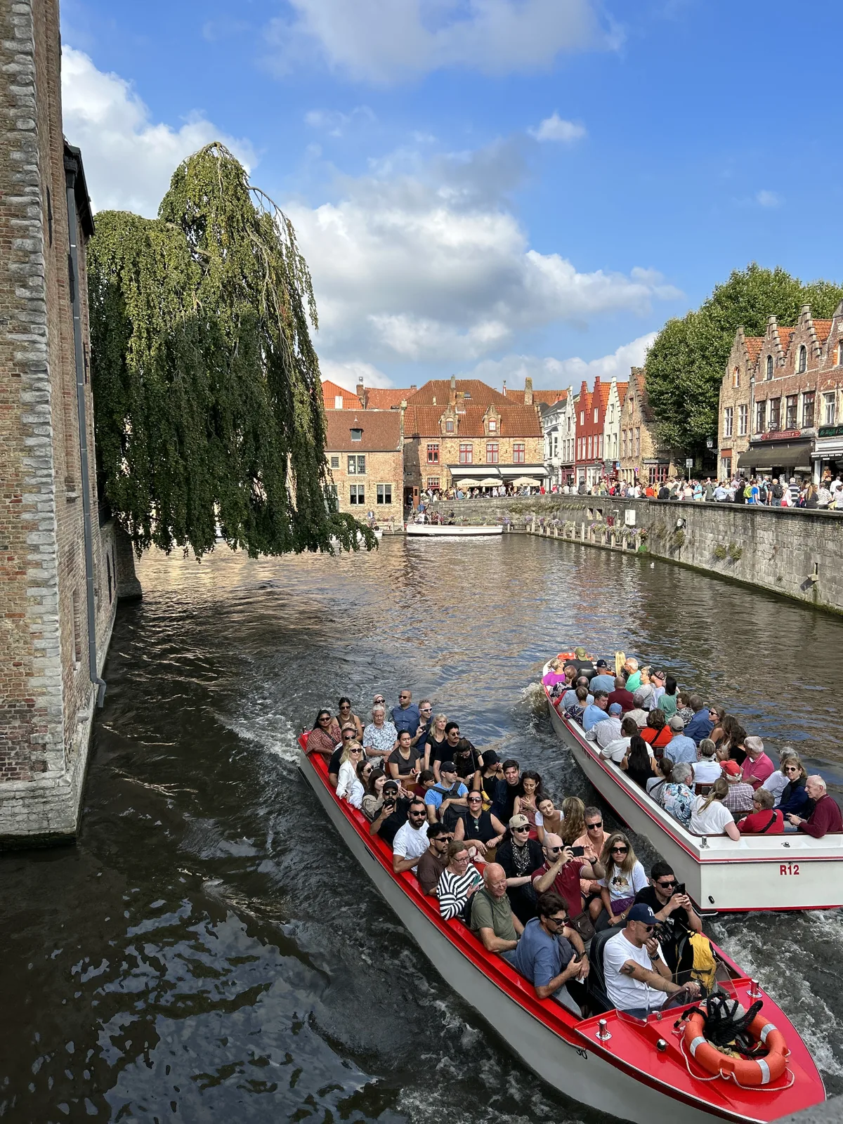 Bateau de promenade sur les canaux de Bruges, vu depuis un pont