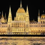 Le Parlement de Budapest illuminé la nuit, vu depuis le bateau sur le Danube