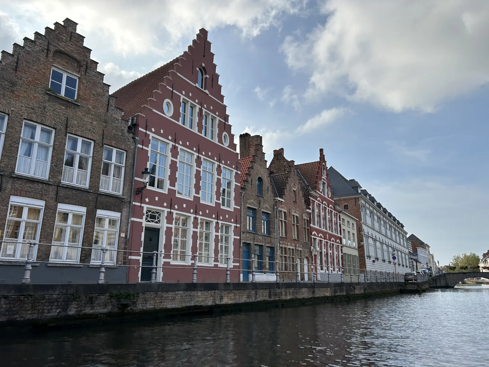 Maisons en brique à pignons le long d'un canal de Bruges, vues depuis le bateau