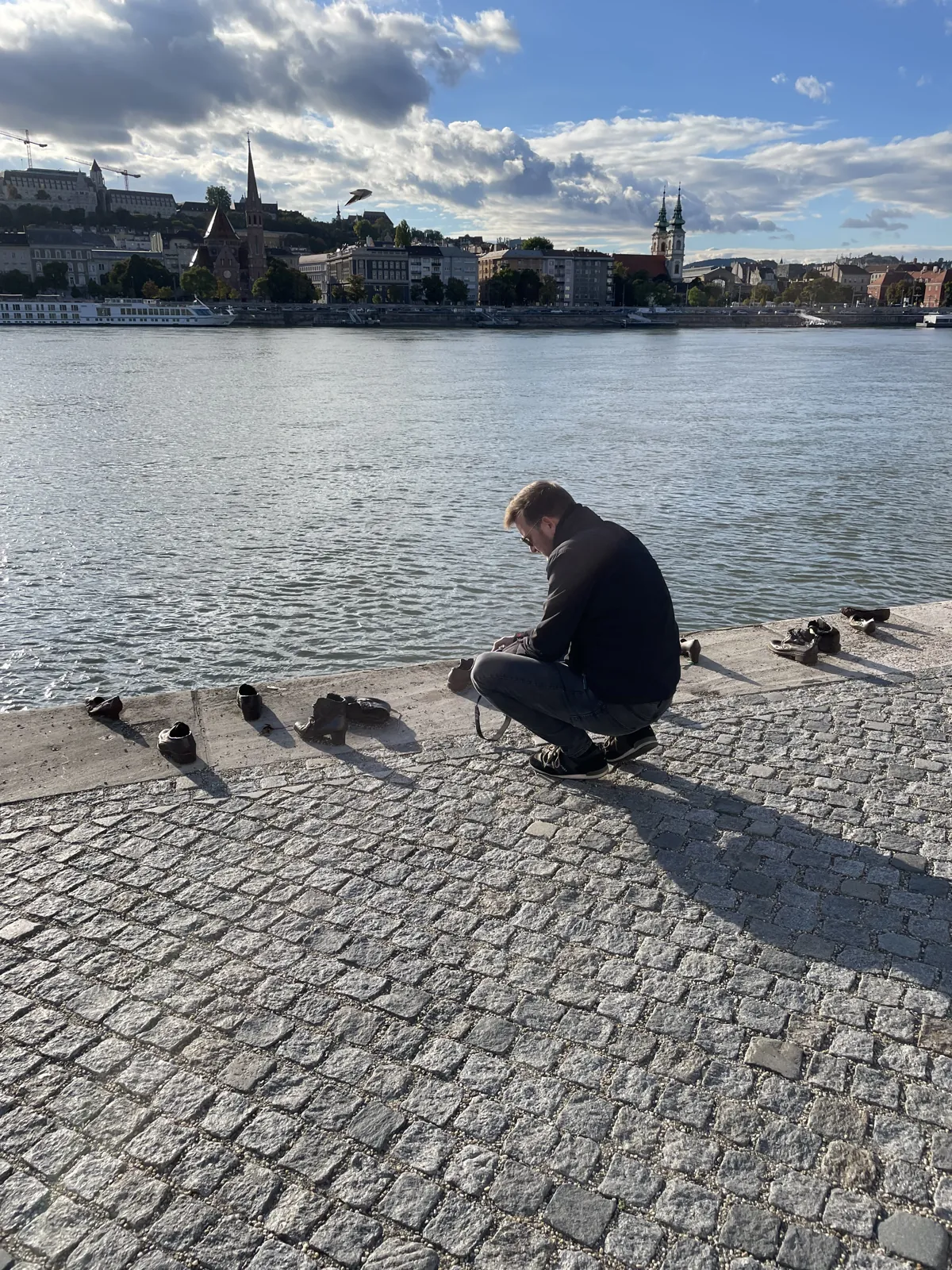 Budapest en 4 jours : mon carnet de voyage et mes bonnes adresses testées sur place 27 Mike accroupi devant les chaussures de bronze du mémorial au bord du Danube