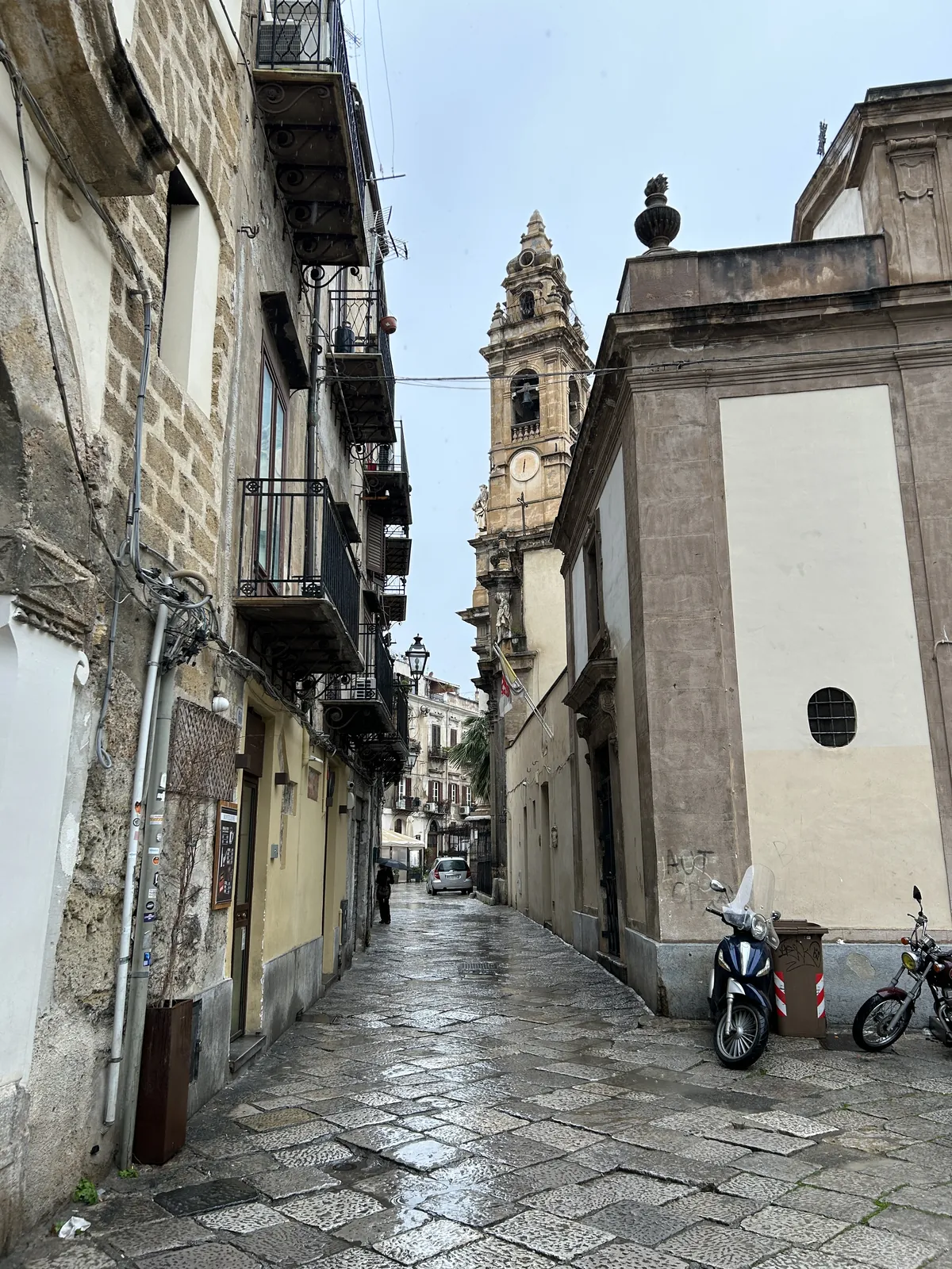 Visiter Palerme en 3 jours : mon carnet de voyage testé sur place 15 Une des premières ruelles du centre historique, avec un clocher baroque au bout